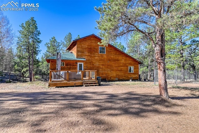 rear view of property with fence and a deck