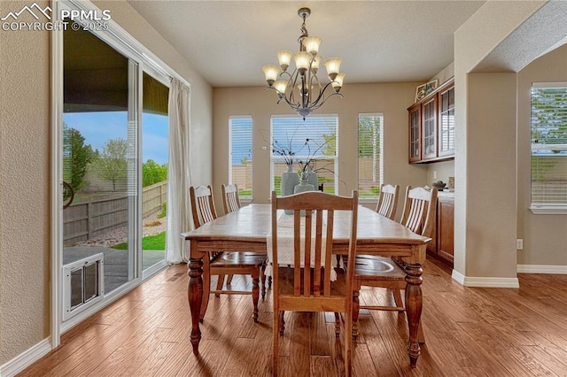 9539 Lizard Rock Trl, Colorado Springs, CO 80924 - dining space featuring baseboards, a notable chandelier, plenty of natural light, and light wood-style floors