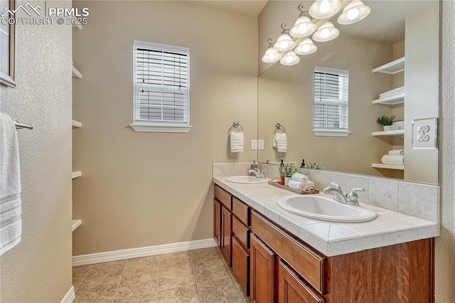 9539 Lizard Rock Trl, Colorado Springs, CO 80924 - bathroom with a sink, baseboards, tile patterned floors, and double vanity