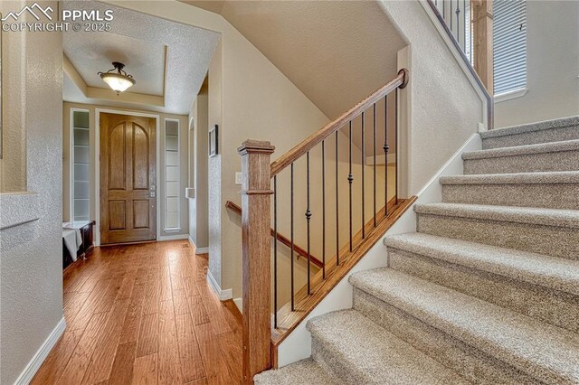 9539 Lizard Rock Trl, Colorado Springs, CO 80924 - entryway featuring a textured wall, stairway, and hardwood / wood-style floors