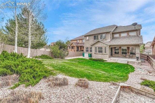 9539 Lizard Rock Trl, Colorado Springs, CO 80924 - rear view of house featuring a fenced backyard, roof with shingles, stucco siding, a patio area, and a lawn