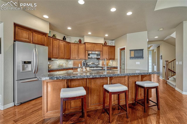 9539 Lizard Rock Trl, Colorado Springs, CO 80924 - kitchen featuring brown cabinetry, a sink, dark wood-style flooring, and stainless steel appliances