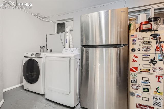 laundry area featuring baseboards, washer and dryer, and laundry area