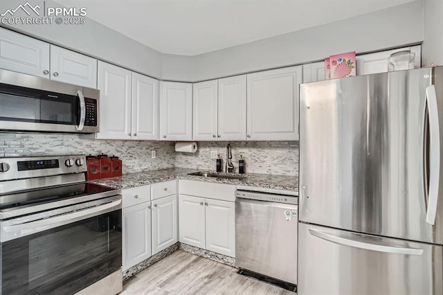 kitchen featuring white cabinets, appliances with stainless steel finishes, and a sink
