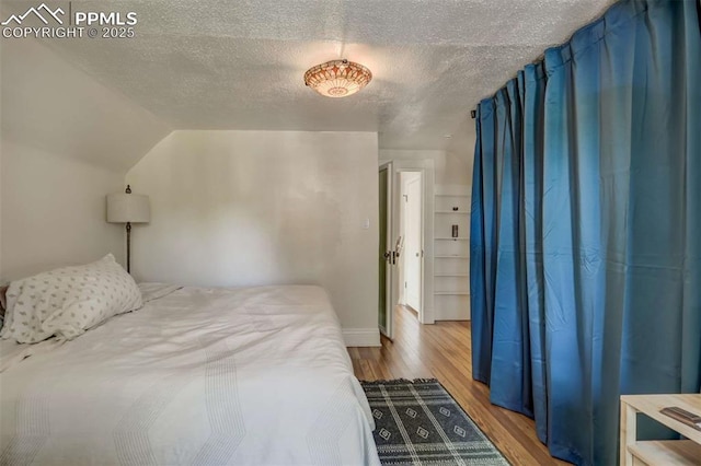 519 W Bijou St, Colorado Springs, CO 80905 - bedroom with baseboards, wood finished floors, a textured ceiling, and lofted ceiling