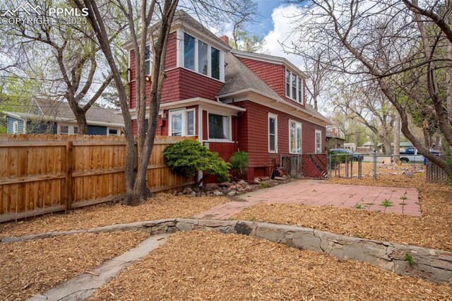 519 W Bijou St, Colorado Springs, CO 80905 - view of side of property featuring fence and roof with shingles