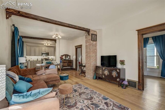 519 W Bijou St, Colorado Springs, CO 80905 - living area with visible vents, light wood-type flooring, and a chandelier