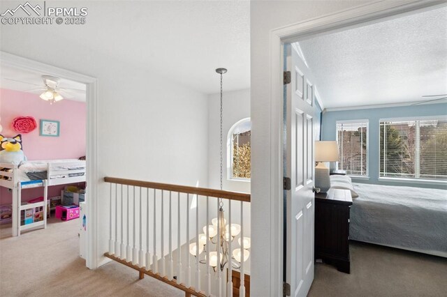 hallway featuring an inviting chandelier and carpet floors