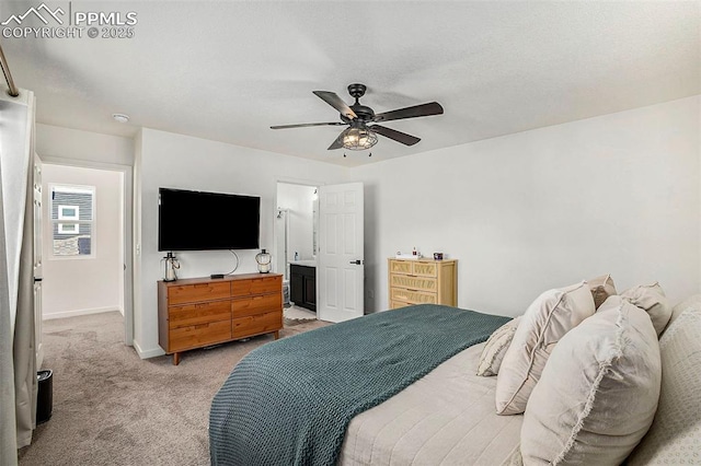 bedroom featuring ensuite bath, a ceiling fan, baseboards, and light carpet