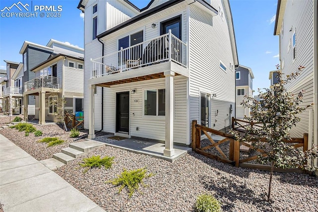view of front facade with board and batten siding and a balcony