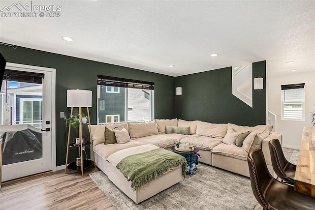 living room with baseboards, wood finished floors, recessed lighting, and a textured ceiling