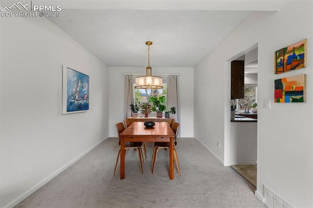 840 Quail Lake Cir, Colorado Springs, CO 80906 - dining area featuring a notable chandelier, light carpet, and a healthy amount of sunlight