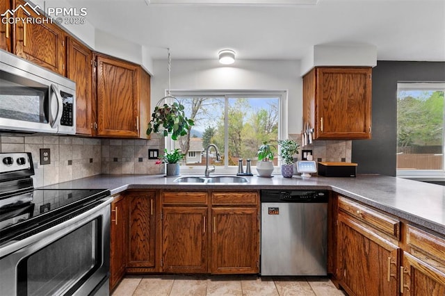 840 Quail Lake Cir, Colorado Springs, CO 80906 - kitchen with backsplash, a sink, appliances with stainless steel finishes, and brown cabinetry