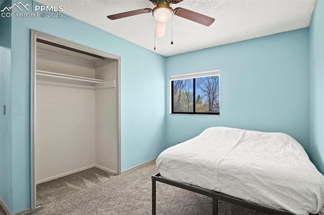 carpeted bedroom featuring ceiling fan, baseboards, a textured ceiling, and a closet