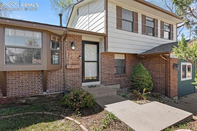 view of exterior entry featuring brick siding