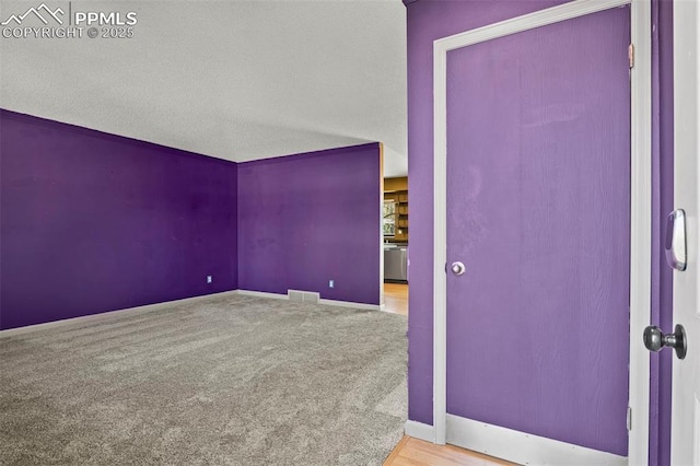 empty room with baseboards, carpet floors, and visible vents