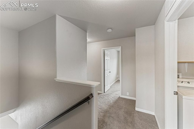 corridor featuring washer / dryer, carpet floors, and baseboards
