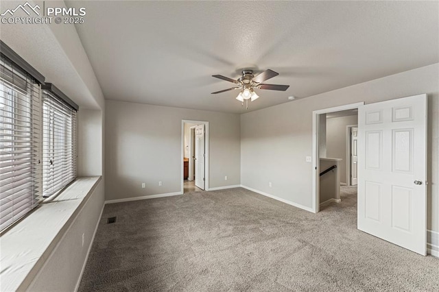 unfurnished bedroom featuring visible vents, baseboards, ensuite bathroom, a ceiling fan, and carpet