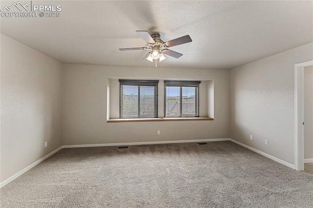 carpeted spare room with a textured ceiling, ceiling fan, and baseboards