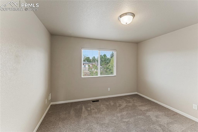 carpeted empty room featuring a textured ceiling, baseboards, and visible vents