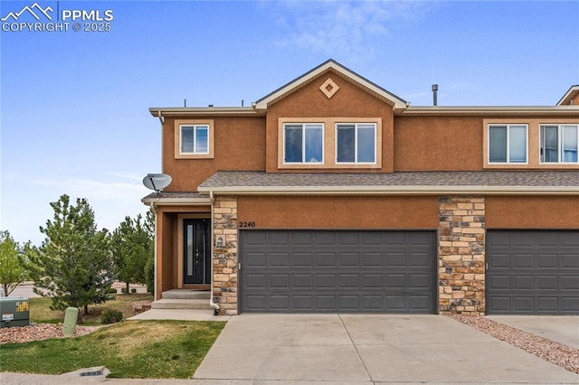 view of property featuring concrete driveway, an attached garage, stone siding, and stucco siding