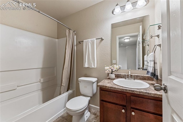 bathroom with vanity, a textured wall, toilet, baseboards, and shower / bath combo