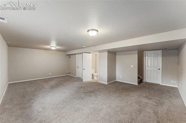 finished below grade area featuring carpet flooring, baseboards, and stairway