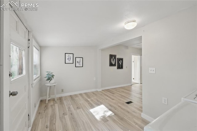 foyer featuring light wood-style flooring and baseboards