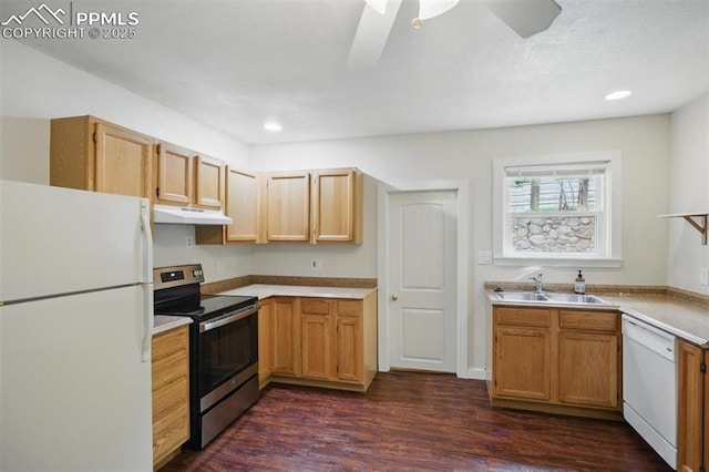 kitchen featuring white appliances, under cabinet range hood, a sink, dark wood-style floors, and light countertops