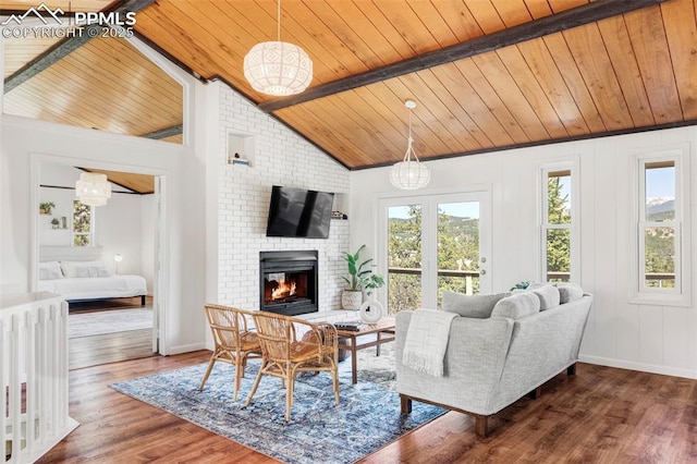 280 Highland Meadows Dr, Florissant, CO 80816 - living area featuring wood finished floors, vaulted ceiling with beams, wooden ceiling, baseboards, and a brick fireplace