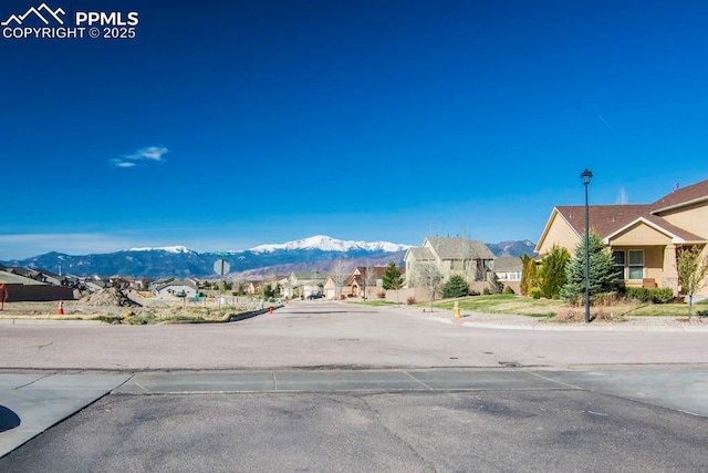 10833 Creede Creek Pt, Colorado Springs, CO 80908 - view of road featuring curbs, street lights, a mountain view, and a residential view