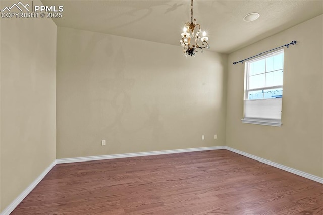 10833 Creede Creek Pt, Colorado Springs, CO 80908 - spare room with an inviting chandelier, baseboards, and wood finished floors