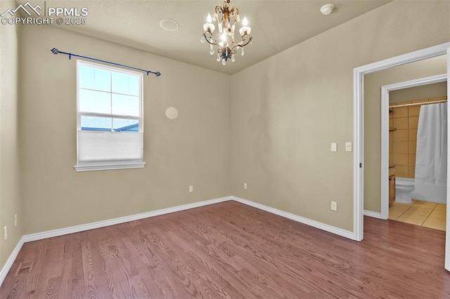 10833 Creede Creek Pt, Colorado Springs, CO 80908 - spare room with baseboards, wood finished floors, and a chandelier