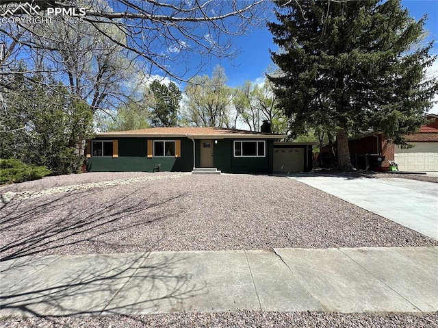 ranch-style home featuring concrete driveway and a garage