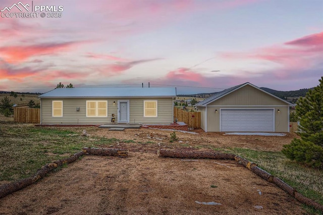 ranch-style house with fence and a detached garage