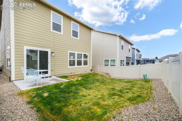 rear view of property featuring a fenced backyard, a patio area, and a yard
