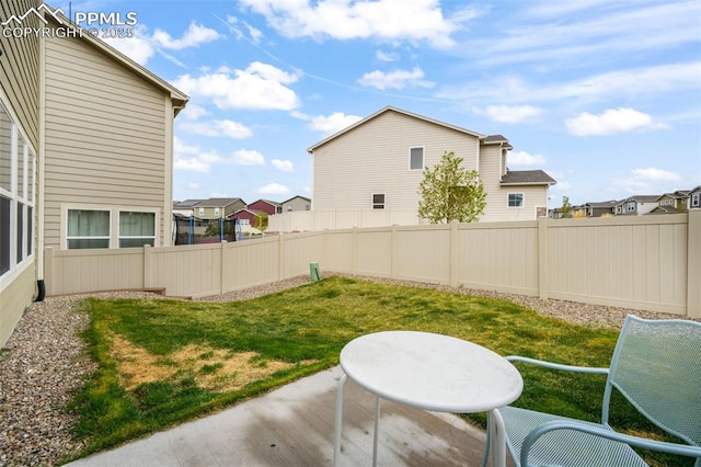 view of yard featuring a fenced backyard, a patio area, and a residential view