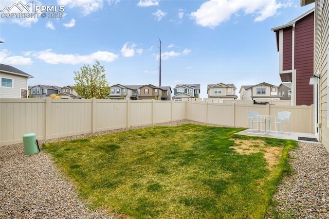 view of yard featuring a patio, a residential view, and a fenced backyard