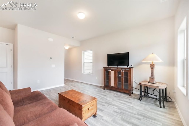 living area with baseboards and wood finished floors