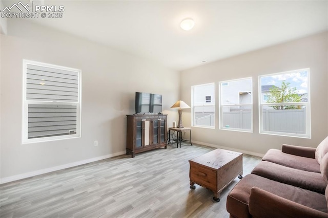 living area with baseboards and wood finished floors