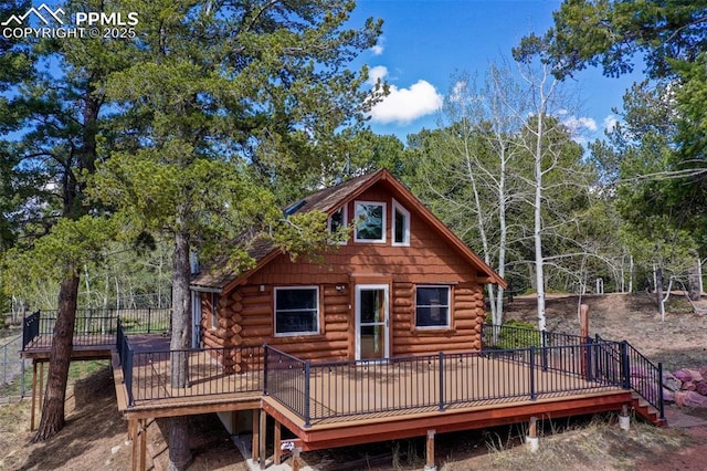 back of house with log siding and a wooden deck