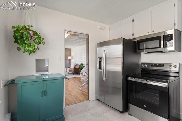 kitchen with ceiling fan, white cabinetry, appliances with stainless steel finishes, and light tile patterned flooring