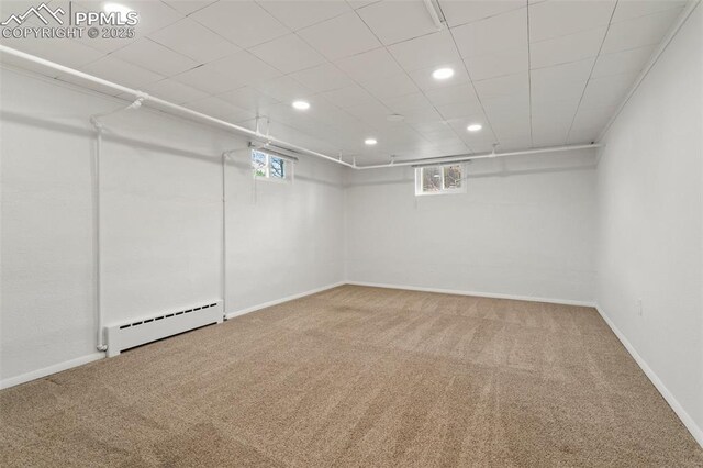 below grade area with carpet, recessed lighting, a baseboard radiator, and a healthy amount of sunlight