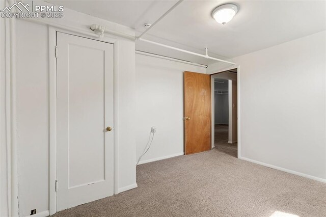 unfurnished bedroom featuring carpet floors and baseboards
