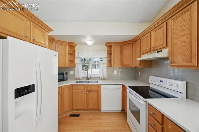 kitchen with open shelves, a sink, light wood-style floors, under cabinet range hood, and white appliances
