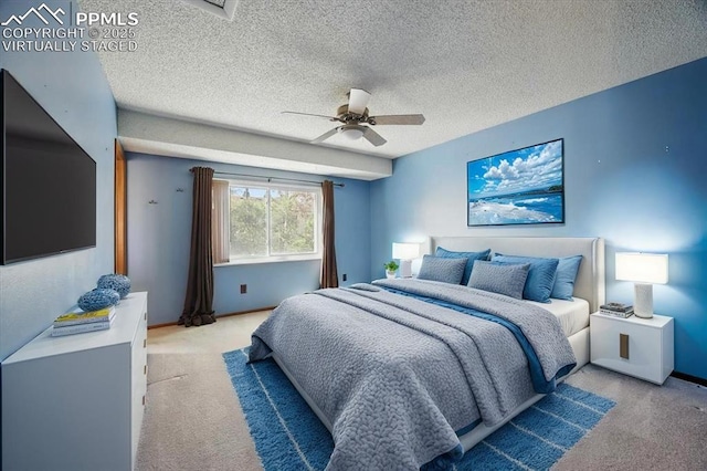 bedroom featuring a ceiling fan, a textured ceiling, and light colored carpet