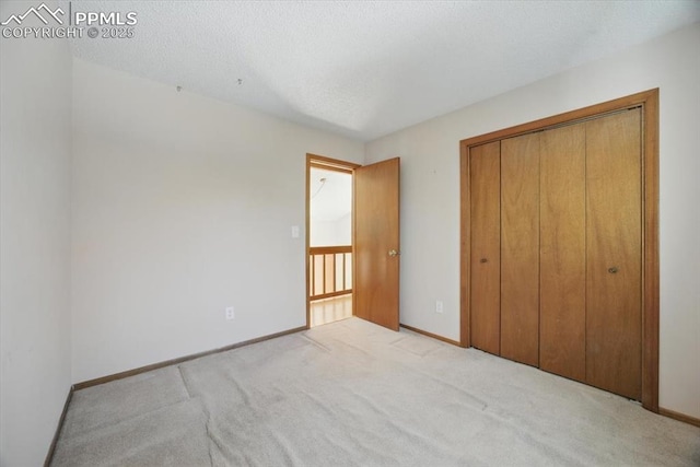 unfurnished bedroom with carpet flooring, baseboards, and a closet