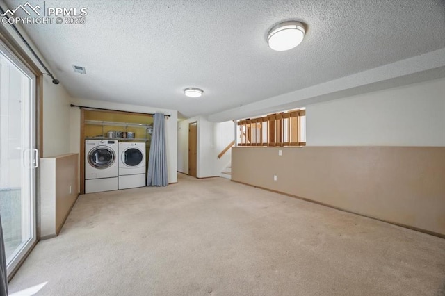 laundry room with carpet floors, a textured ceiling, laundry area, and washing machine and dryer