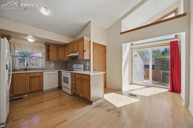 kitchen featuring visible vents, white appliances, light countertops, brown cabinets, and light wood-style flooring
