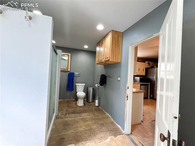 interior space with recessed lighting, toilet, and baseboards